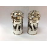 Pair of silver pepper and salts with pierced decoration and blue glass liners