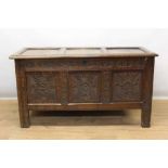 17th century carved oak coffer, with triple panel hinged top and scroll carved frieze over triple ca