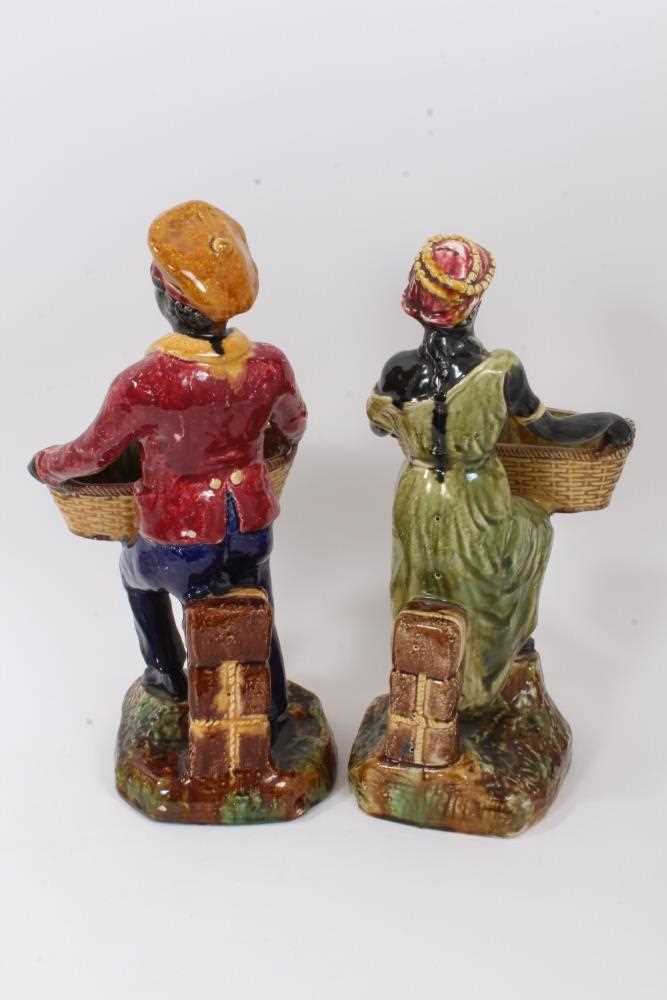 Pair of continental majolica figures, late 19th century, shown holding baskets and standing on grass - Image 3 of 5