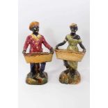 Pair of continental majolica figures, late 19th century, shown holding baskets and standing on grass