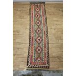 Kelim style runner, with repeat lozenge medallion in muted tones, 289 x 74cm