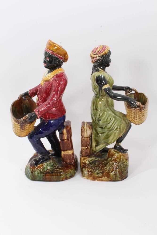 Pair of continental majolica figures, late 19th century, shown holding baskets and standing on grass - Image 2 of 5