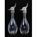 A pair of modern mallet-shaped glass decanters, the hinged tops formed as silver plated lapwing's he