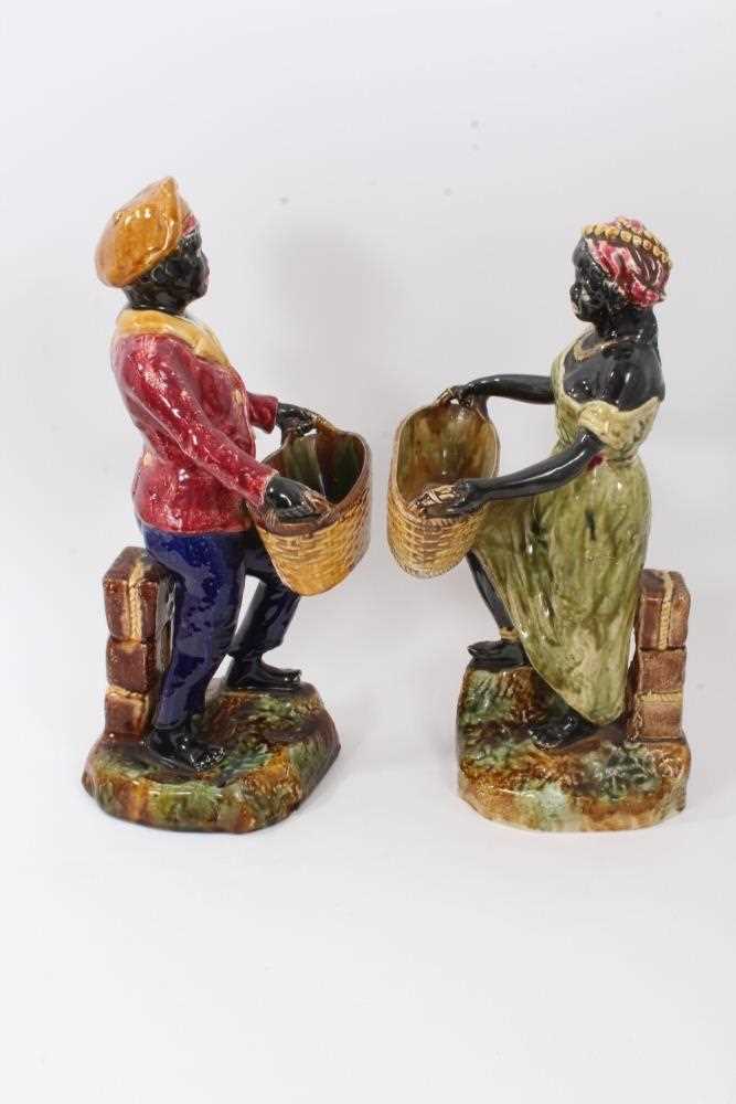 Pair of continental majolica figures, late 19th century, shown holding baskets and standing on grass - Image 4 of 5
