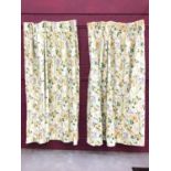 Three pairs of yellow and blue floral interlined curtains with green foliage on cream ground, the pi