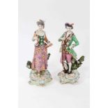 A pair of Chelsea/Derby bocage figures of huntsman and companion, circa 1765, modelled standing hold