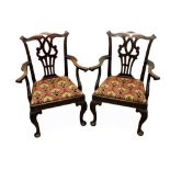 A pair of mahogany open armchairs, with needlework seats