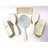 Ivory dressing table set, to include four brushes, a mirror and a dish, retailed by Barrett & Sons,