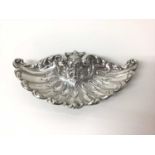 Good quality sterling silver dish, of shell form, repousse decorated with scrollwork motifs and a gr