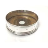 Contemporary silver wine coaster with beaded border and turned wooden base, 13cm diameter