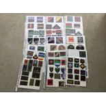 21 sheets of British, American and other cloth military badges mounted onto sheets of A4 paper