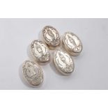 Group of five white metal pill boxes and covers, the tops with embossed decoration of The Life Guard