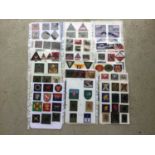 18 sheets of British, American and other cloth military badges mounted onto sheets of A4 paper