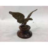 Brass car mascot in the form of an Eagle, mounted on a wooden base, possibly for an Alvis, 15.5cm in