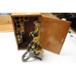 Large brass binocular microscope by Swift & Son, c.1880s, in wooden case holding eyepieces and lense