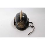 1920's German steel Fireman's helmet in black painted finish with brass comb, badge and chin strap,