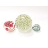 Very large art glass paperweight with bubble decoration, together with two other colourful glass pap