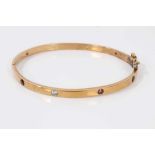 9ct gold hinged bangle set with eight multi coloured sapphires