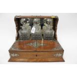 Edwardian oak tantalus with three cut glass cube decanters