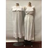 Two Edwardian full length pinafores with broderie anglaise insertd and frilly cap sleeves. Plus thr