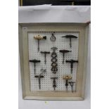 Collection of antique corkscrews, mounted on a board