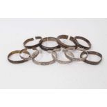 Ten Chinese white metal bangles with floral scroll decoration