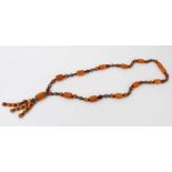 Amber bead necklace with white metal spacers and tassel terminal