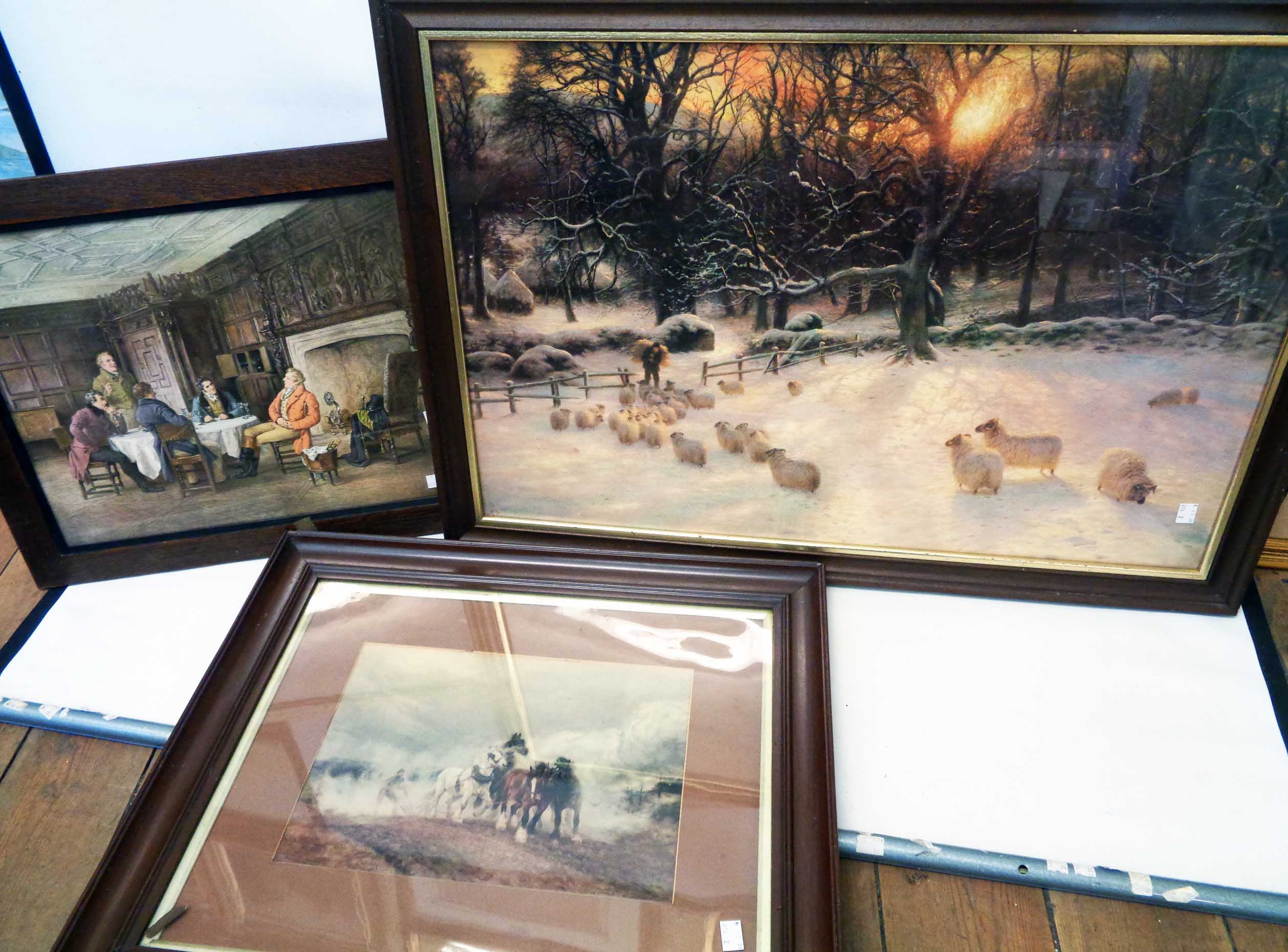 Three large framed coloured prints, depicting sheep in a winter landscape, a plowing team and