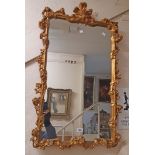 A reproduction ornate gilt framed oblong wall mirror with fleur de lys pediment