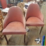 A pair of vintage laminated bentwood barrel back tub chairs upholstered in pink velour, set on