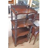 A 19th Century rosewood four tier whatnot with fretwork gallery to top, serpentine front surfaces,