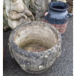 A large concrete garden planter with grape and mask moulding - sold with a terra-cotta vase