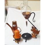 A wrought iron and copper wine carafe with glass vessel, a hammered copper coffee pot, and a