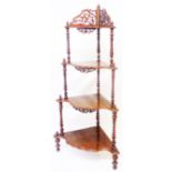 A Victorian style figured walnut veneered four tier what-not with fretwork to top, shaped surfaces