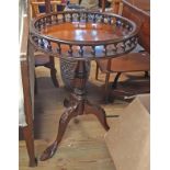 A 46cm diameter Reprodux mahogany pedestal table with gallery to top, set on turned pillar and