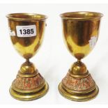A pair of brass goblets with copper friezes of battle scenes