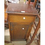 A 37cm 1930's oak work cabinet with upholstered interior to lift top and cupboard under