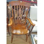 A Novoles stained wood Windsor style high back elbow chair with moulded sectional seat, set on