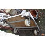 An industrial metal framed wooden decked trolley with large casters