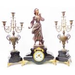 A late Victorian black slate clock garniture with painted spelter figure of a young lady and