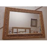 An ornate gilt framed bevelled oblong wall mirror