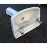 A pedestal sink with taps