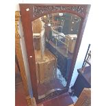 A stained and carved wood framed adapted internal door panel with later decorative mirror panel as a