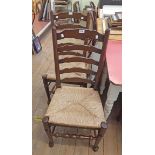 A pair of stained wood framed ladder back dining chairs with woven rush seat panels, set on turned