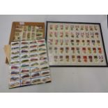 Two framed sets of cigarette cards, board mounted set of stuck down automobile cards and some