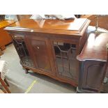 A 1.34m early 20th Century mahogany book cabinet with blind fretwork frieze, central flame