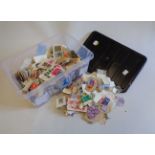 A plastic tub containing a collection of 20th Century world stamps recovered, loose and on paper