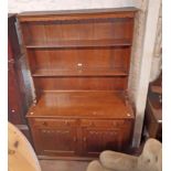 A 1.22m early 20th Century oak two part dresser with two shelf open plate rack over a base with