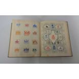 An early 20th Century album containing stuck down crests, monograms and coats of arms