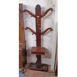 A late Victorian stained walnut hallstand with flanking shaped supports, central mirror, glove box